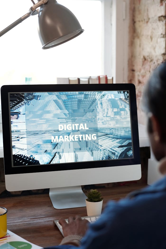 An individual focused on digital marketing on a desktop computer in a cozy workspace.